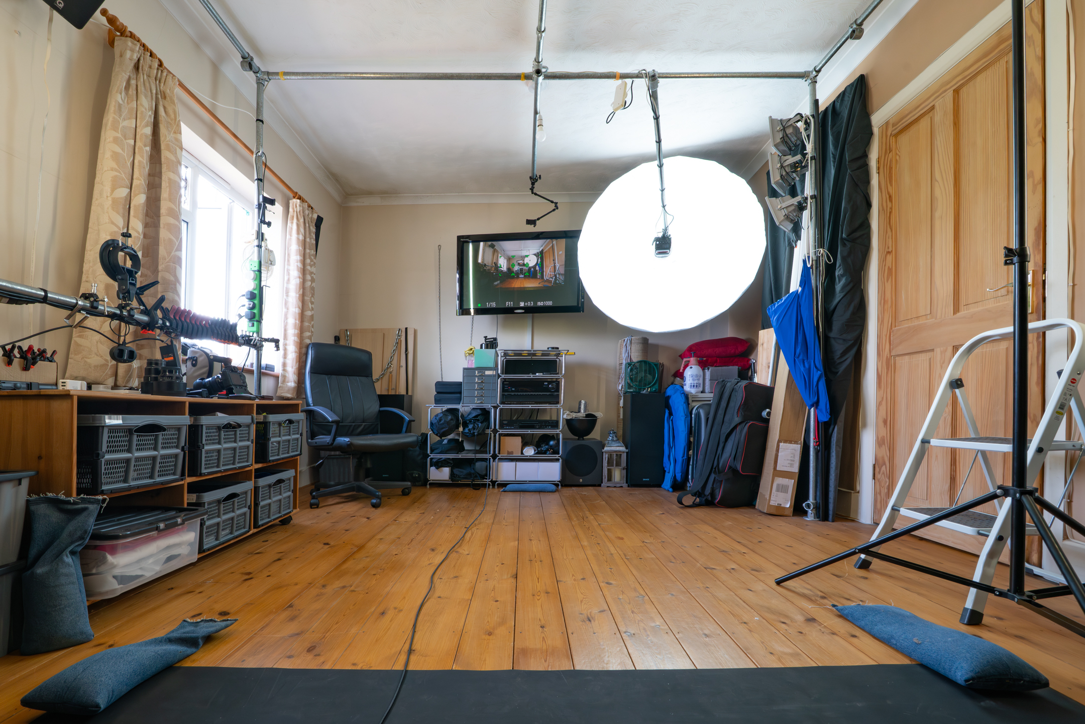 View of the photography studio from the model’s perspective, facing the camera and lighting setup.
