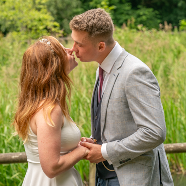 Bride and groom standing close, about to kiss, at Nine Springs in Yeovil during an intimate wedding photoshoot.