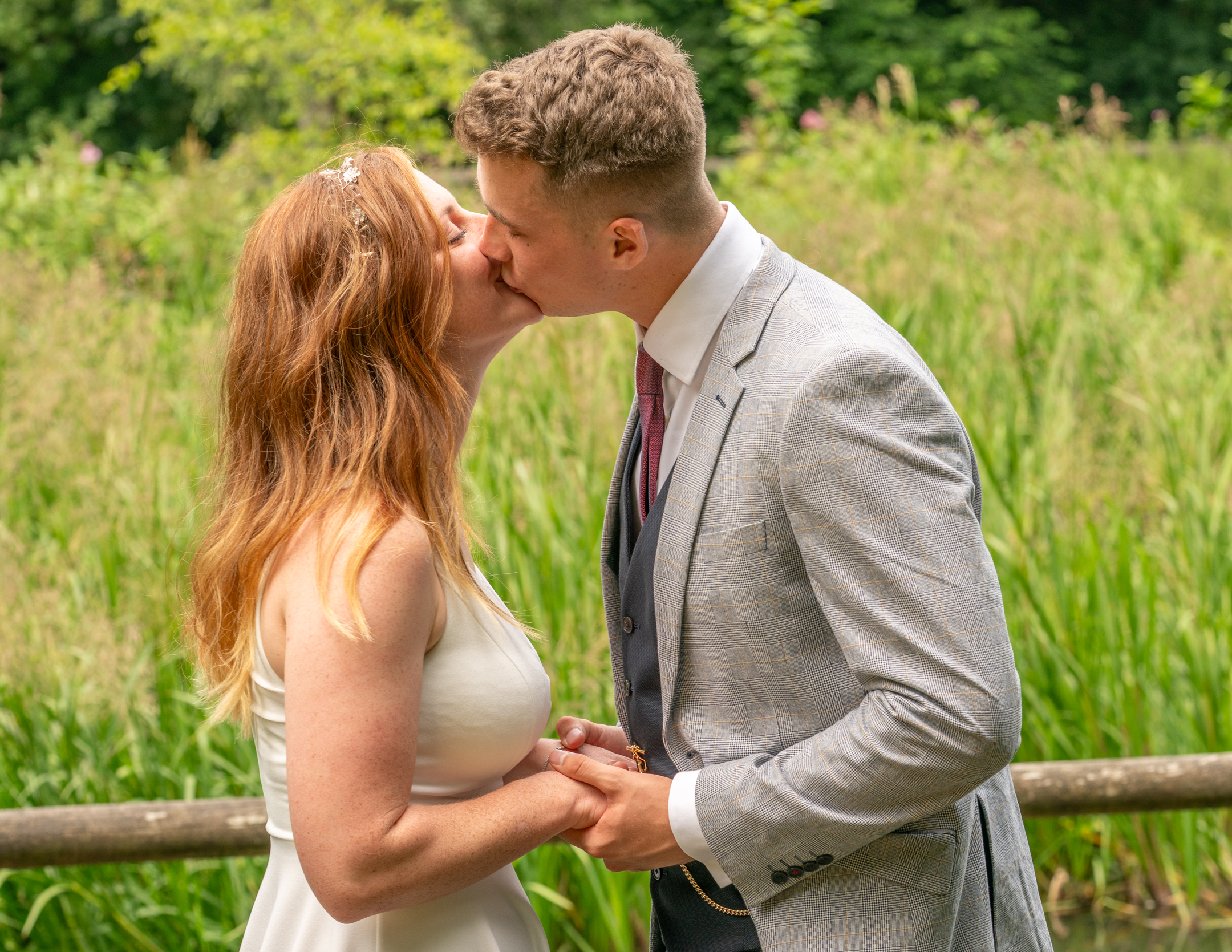 Bride and groom share their first kiss at Nine Springs, Yeovil, captured in a natural and intimate wedding moment.