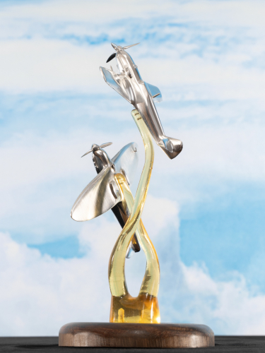 Aluminium sculpture depicting the Battle of Britain in 1940 with a Supermarine Spitfire and Messerschmitt Bf 109 engaged in aerial combat, detailed metallic artwork capturing aircraft from World War II.