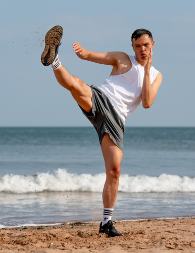 Male model practising Muay Thai kicks on Dawlish Warren shoreline – Jason Reading Photography