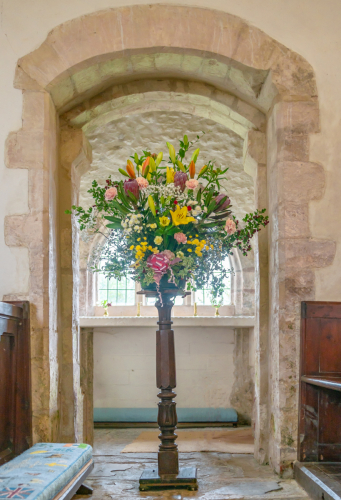 Flower stand arrangement decorating the aisle of Wambrook Church wedding