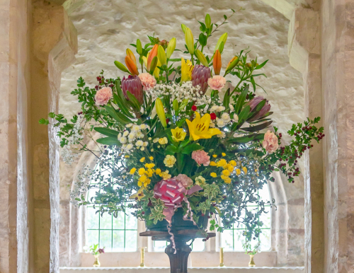Wedding flower arrangement placed along the aisle at Wambrook Church