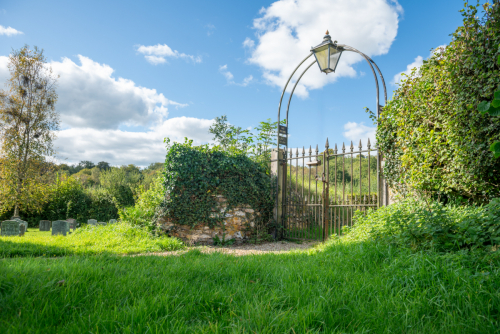 Iron gate entrance with arch and lantern at Wambrook Church wedding venue