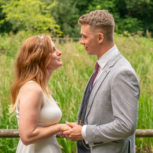 Bride and groom holding hands and gazing into each other’s eyes at Nine Springs, Yeovil