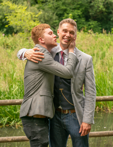 Playful wedding photo as best man pretends to kiss groom at Nine Springs, Yeovil