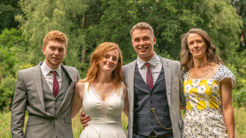 Close-up of four wedding guests smiling with arms around each other at Nine Springs, Yeovil